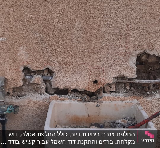 קיר עם חורים, צינורות חשופים וכיור עם כלי עבודה